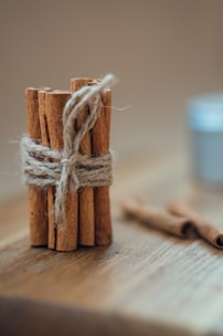 A heap of aromatic cinnamon sticks tied with twine, resting on a burlap sack.