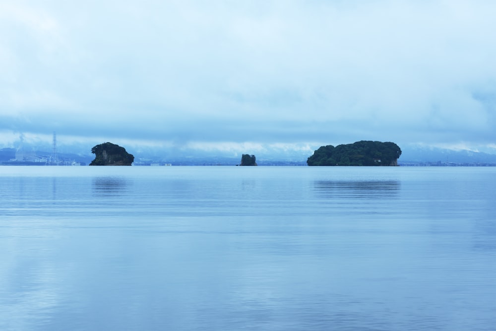 body of water near black rock formation during daytime