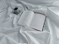 An open notebook with web development sketches and a coffee cup beside it.