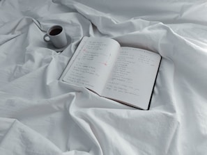 An open notebook with budgeting notes and a cup of coffee.
