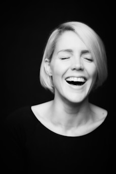 An artistic black-and-white photo of Chloe laughing while reviewing her latest video clips.