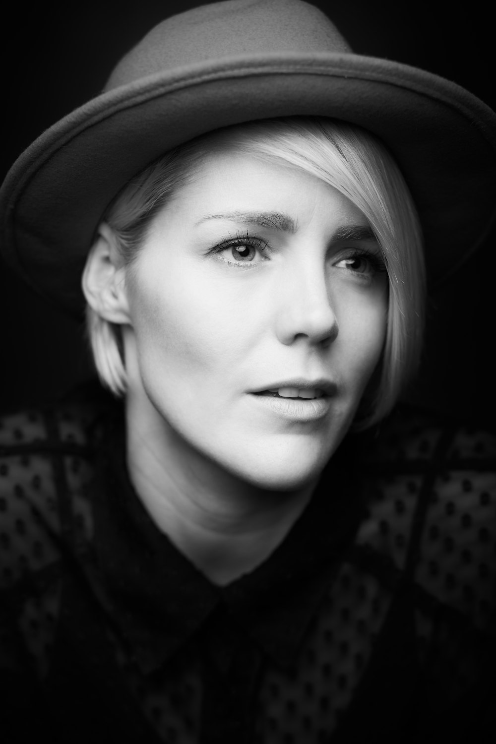 woman in black and white shirt wearing black hat