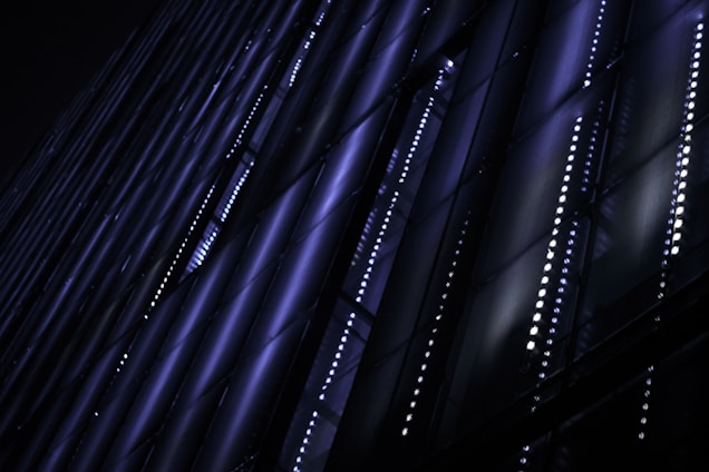 A sleek architectural blueprint illuminated by soft electric cyan lines against a midnight navy background.