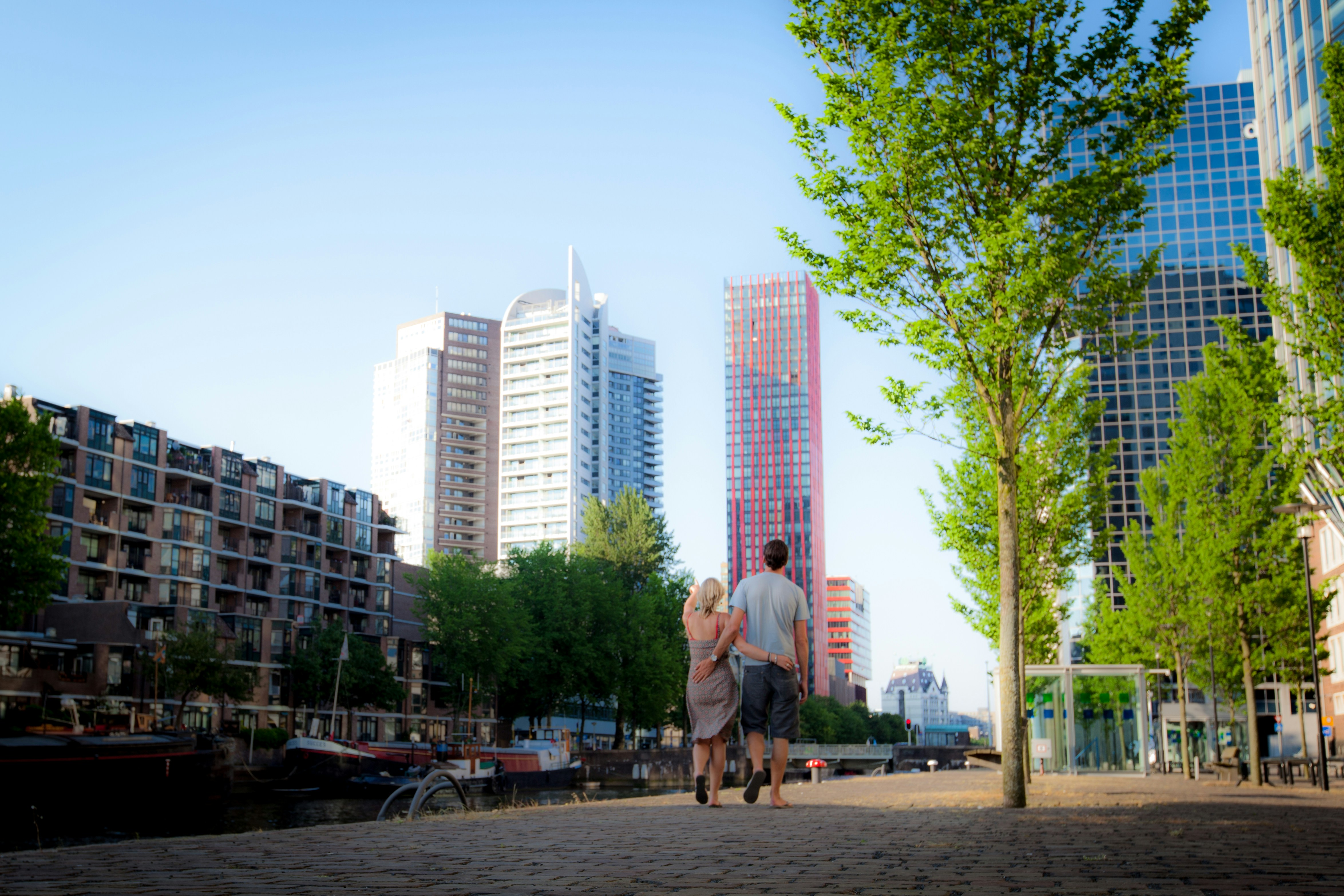 man in brown jacket walking on sidewalk during daytime