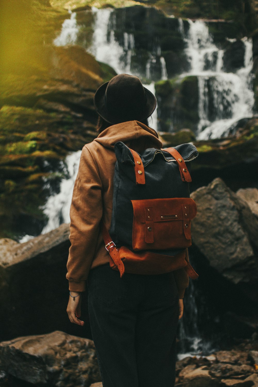 man in brown jacket carrying brown backpack