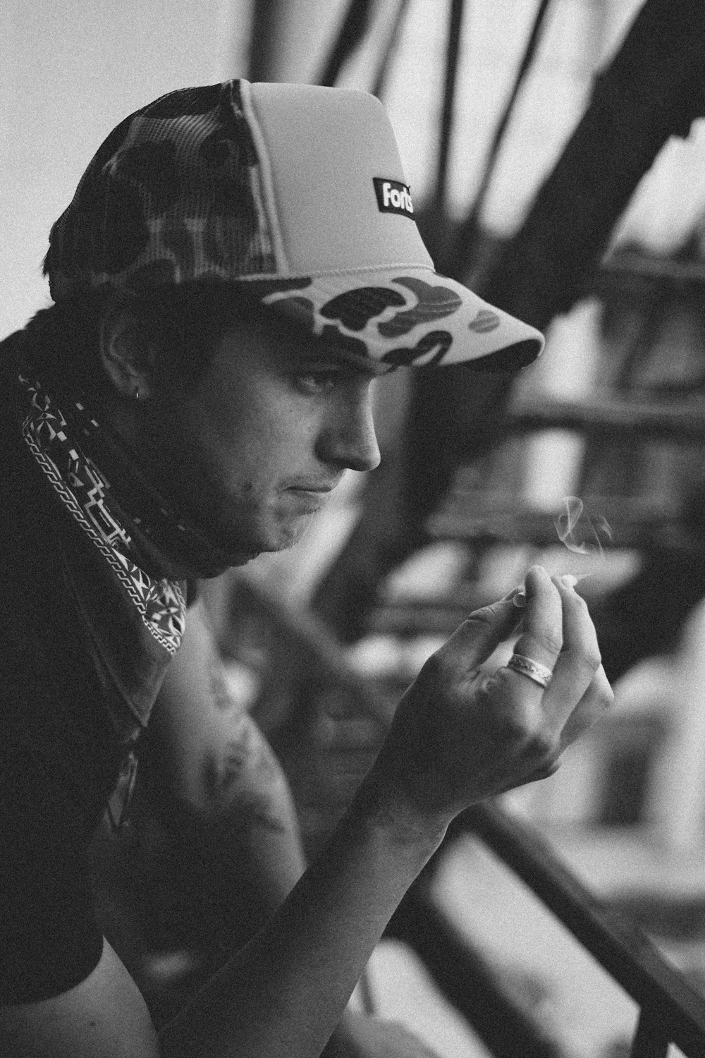 man in black and white fitted cap smoking cigarette