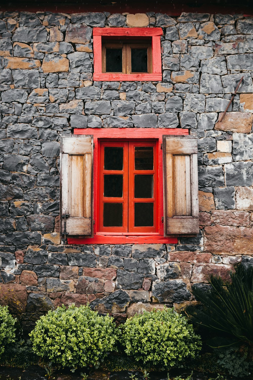 灰色のレンガの壁に赤い木製の窓