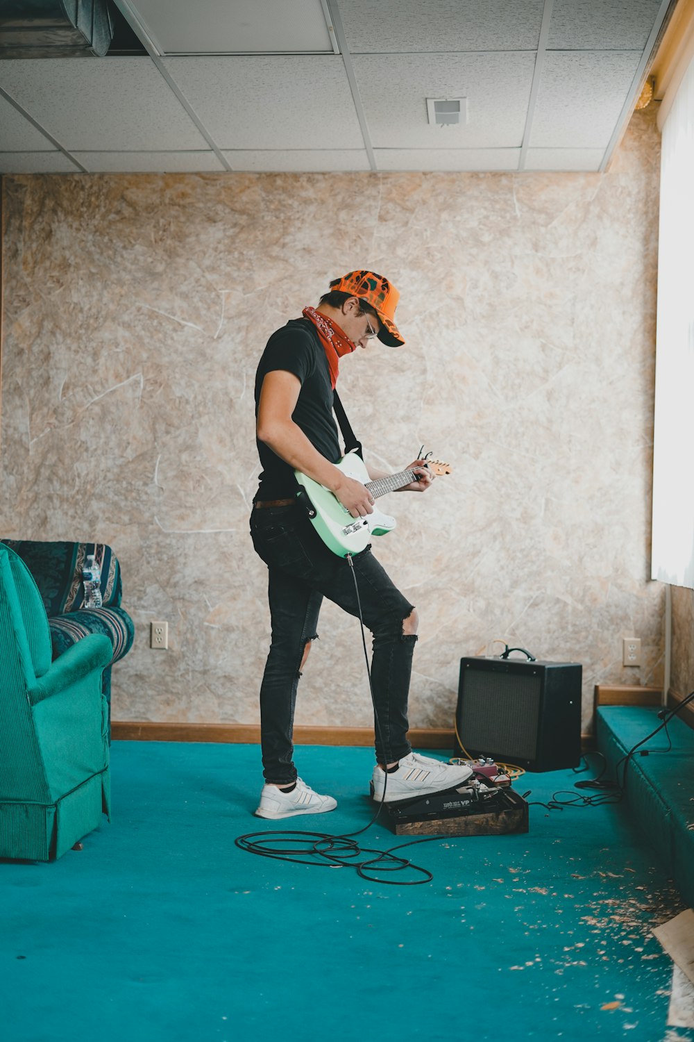 hombre con camiseta negra tocando la guitarra