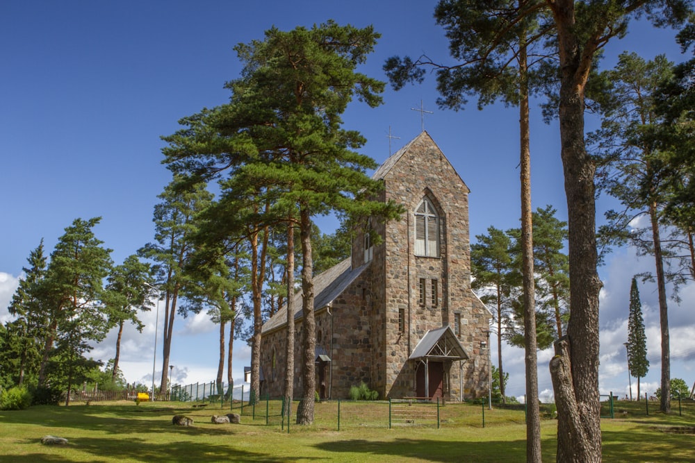 bâtiment en béton brun et gris près d’arbres verts sous un ciel bleu pendant la journée