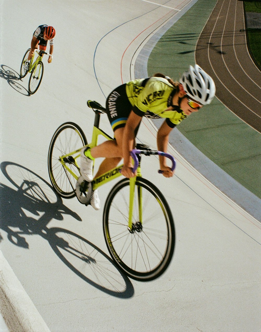 uomo in tuta da bicicletta verde e bianca che va in bicicletta
