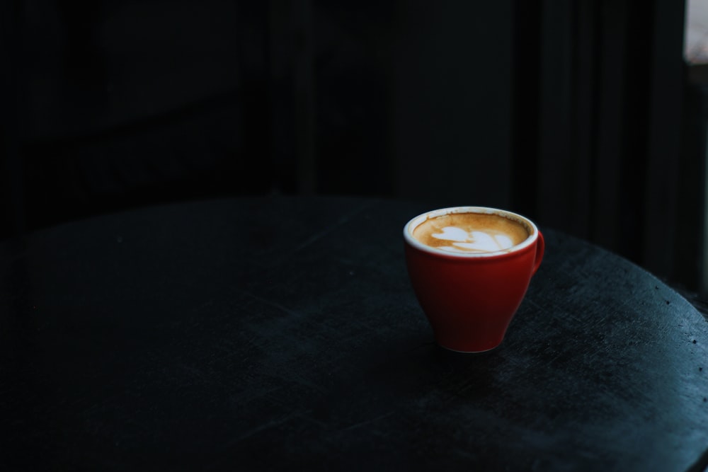 red ceramic cup on black table