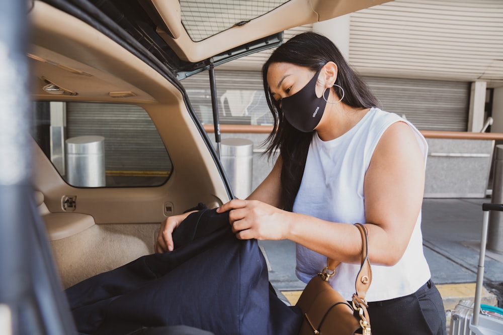 Mujer con camiseta blanca sin mangas con gafas de sol negras sosteniendo textil azul