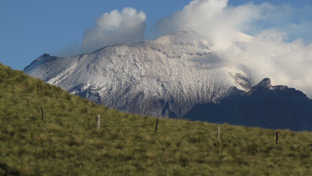 white clouds over snow covered mountain