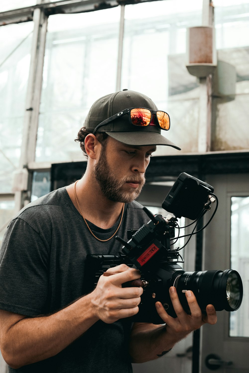 man in black crew neck t-shirt holding black dslr camera