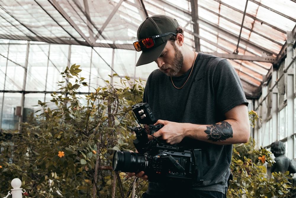 man in black crew neck t-shirt holding black dslr camera