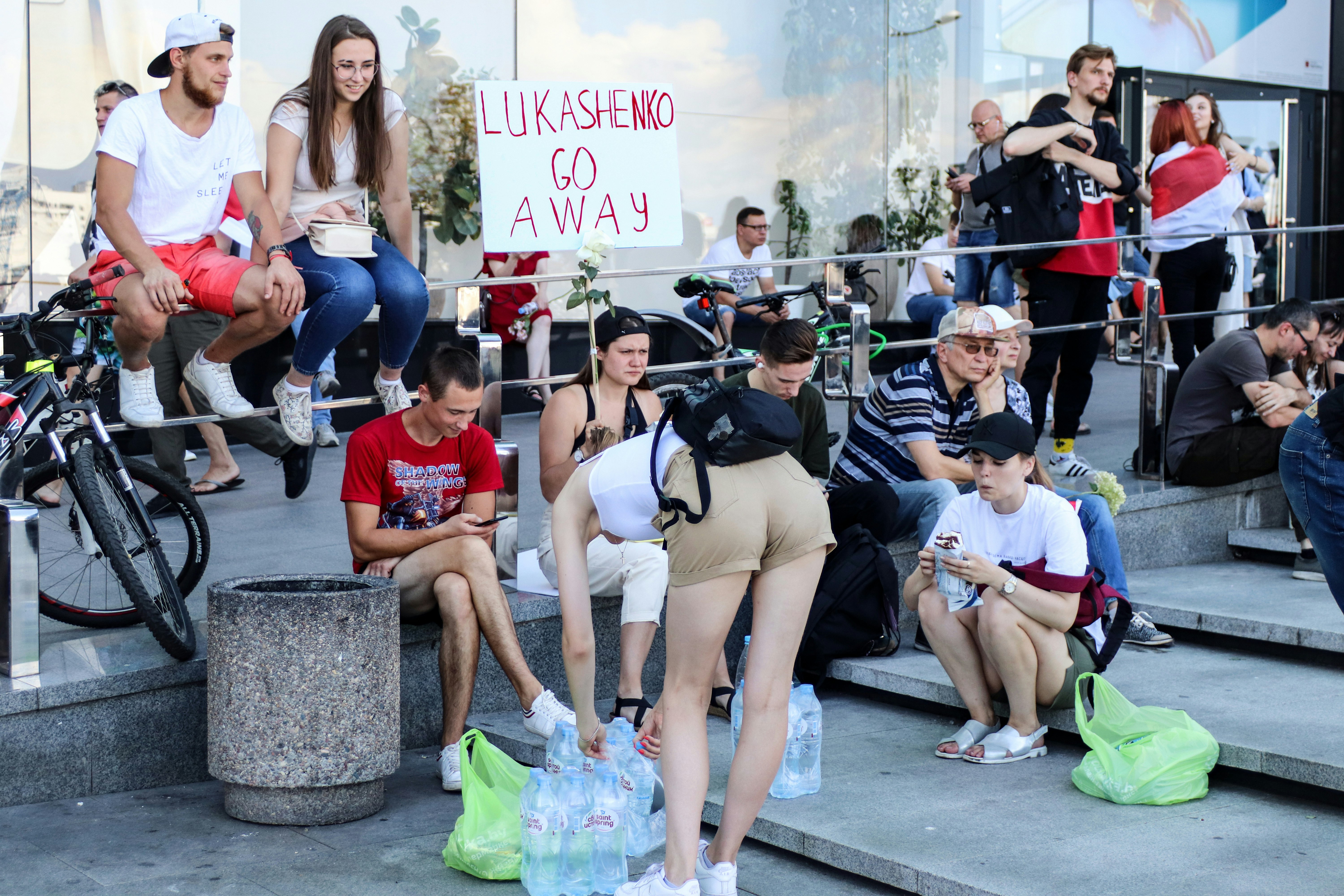 woman in black tank top and white shorts sitting on concrete bench