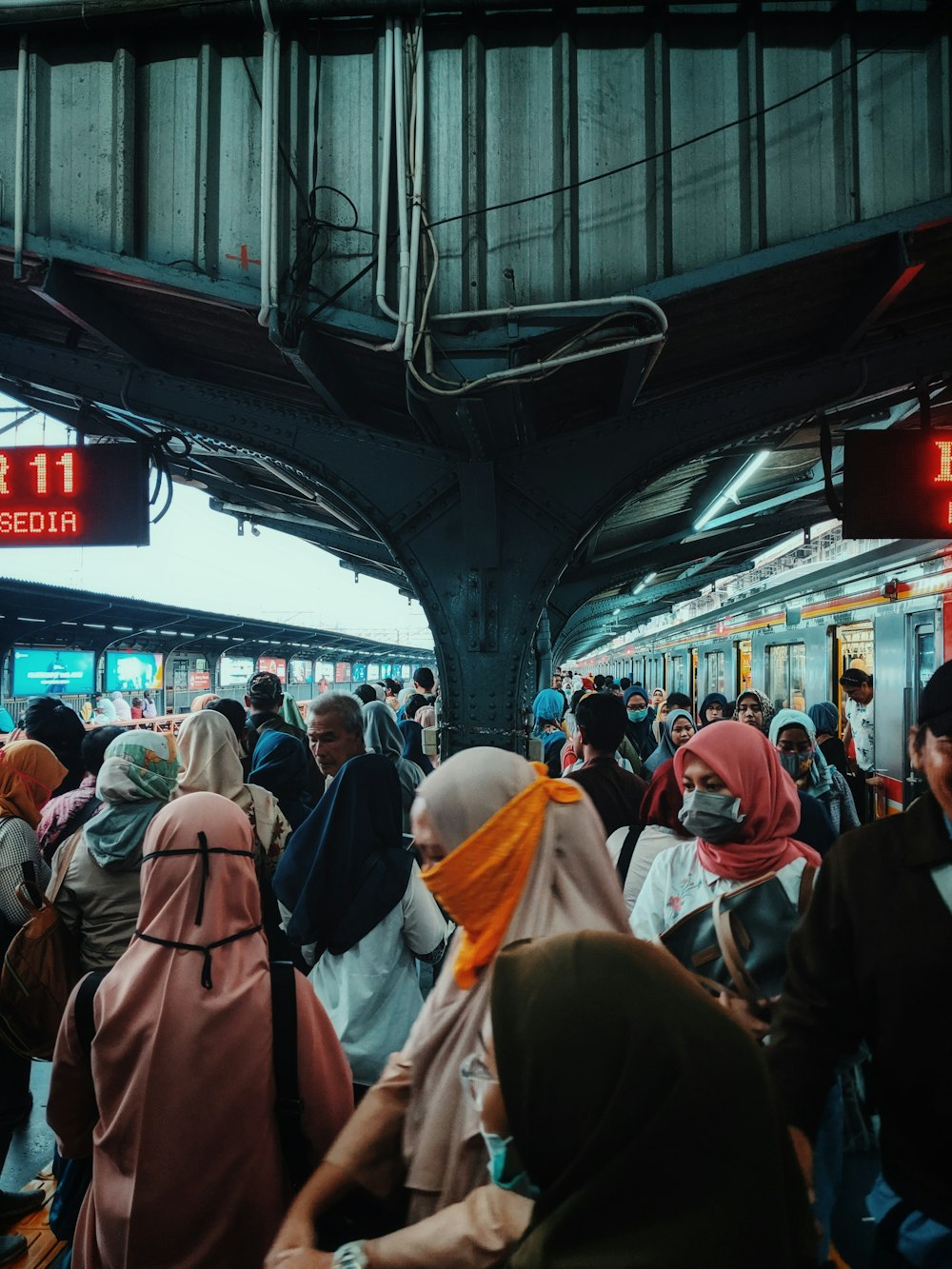 people in white and brown robe walking on train station during daytime