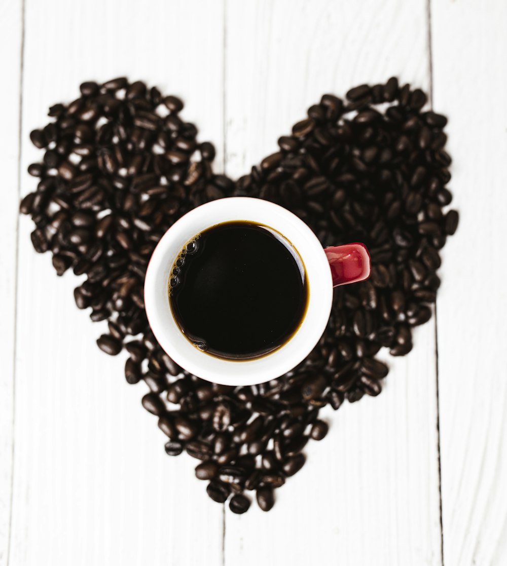 white ceramic mug on coffee beans