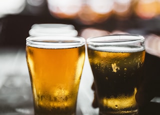 clear drinking glass with beer on black table