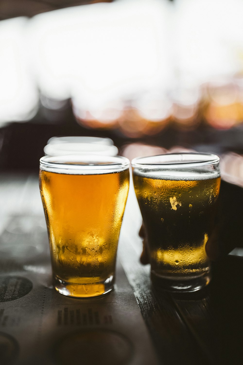 verre à boire clair avec de la bière sur une table noire