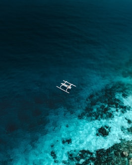 white and brown wooden boat on blue sea water during daytime