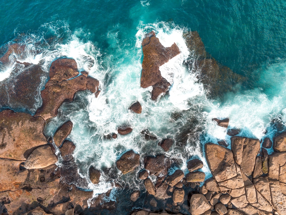 brown and gray rock formation on body of water during daytime