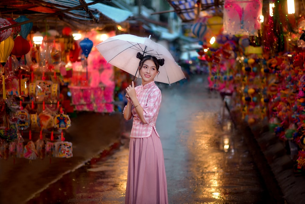 woman in pink dress holding umbrella