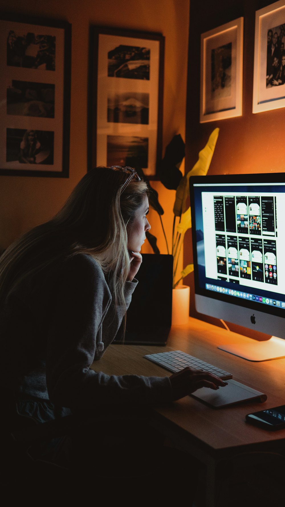 woman in black long sleeve shirt sitting in front of silver imac