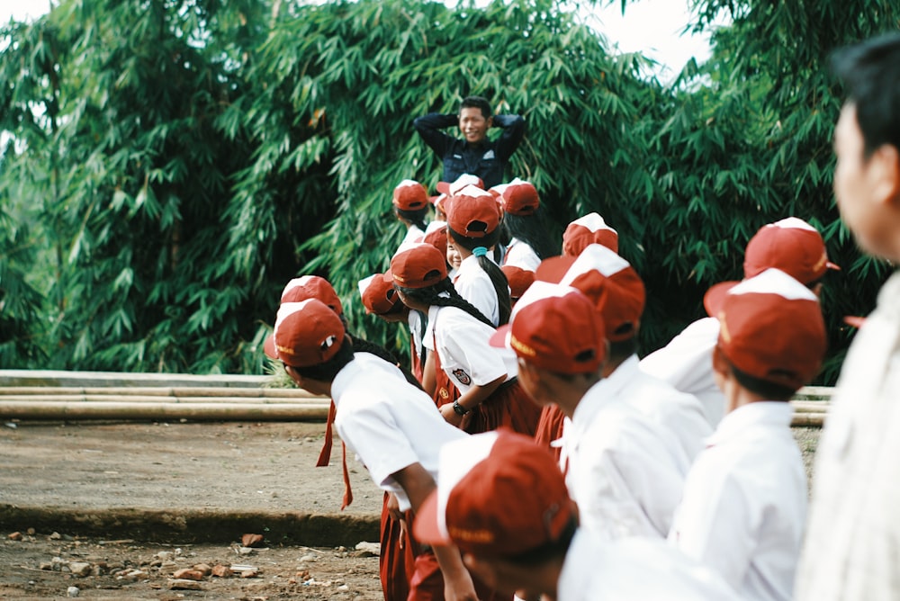 people in white uniform sitting on bench during daytime