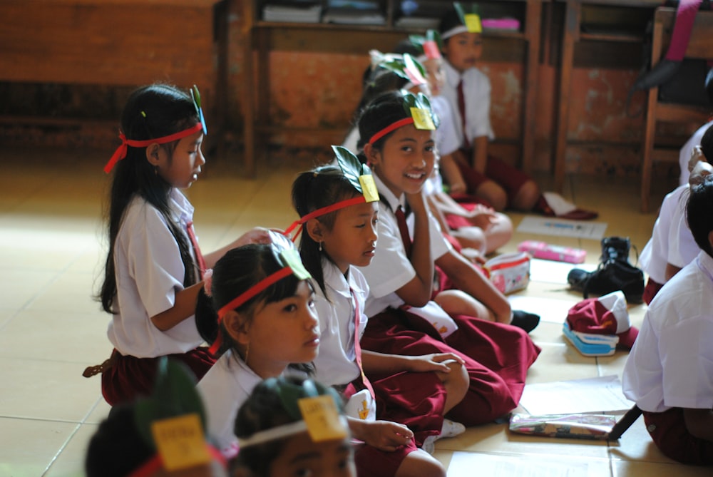 girl in white school uniform sitting on floor