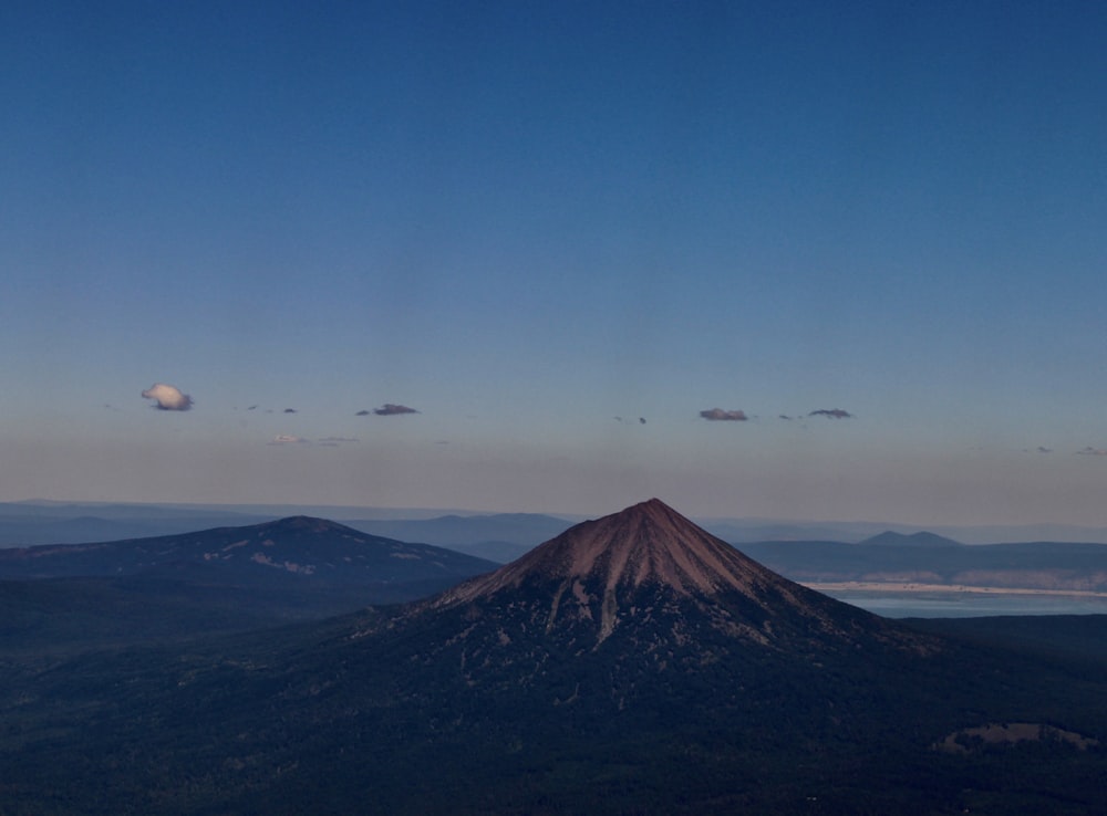 birds flying over the mountain during daytime