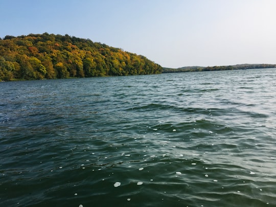 green and brown mountain beside body of water during daytime in Maplewood State Park United States
