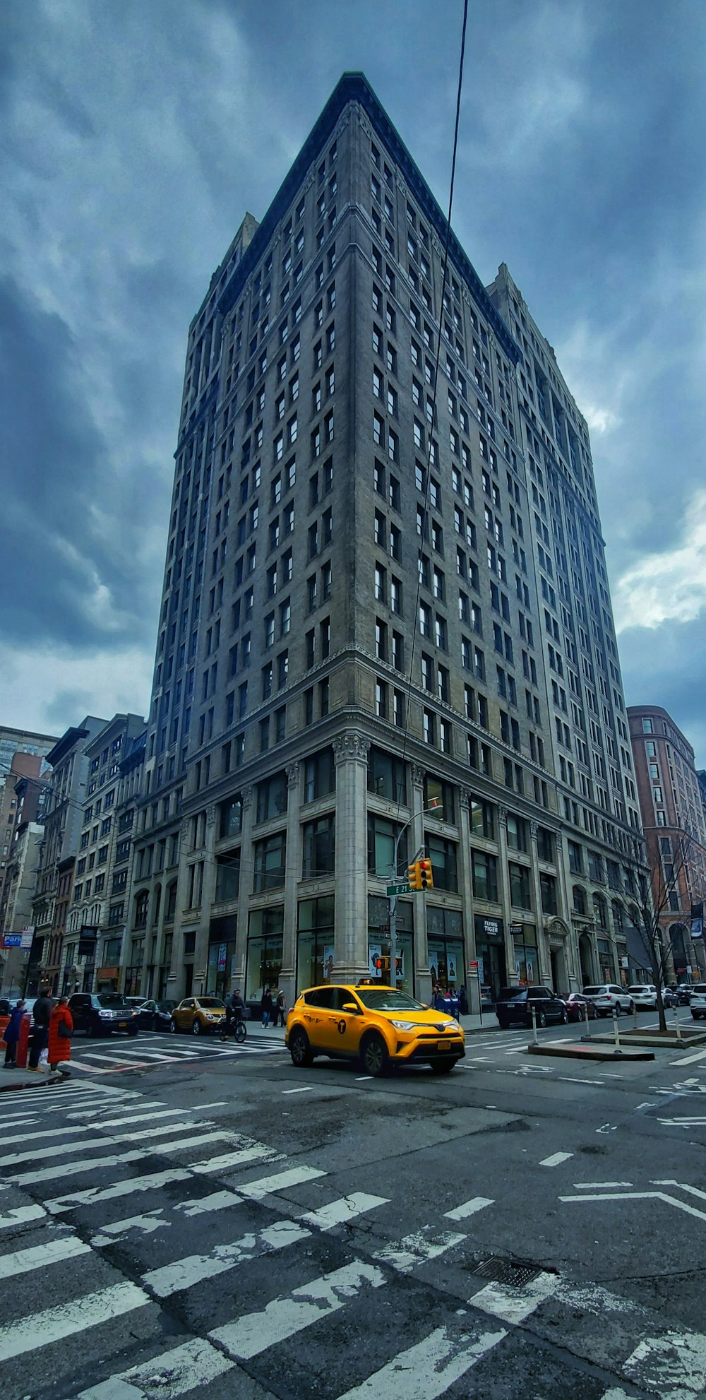 yellow taxi cab on road near high rise building during daytime