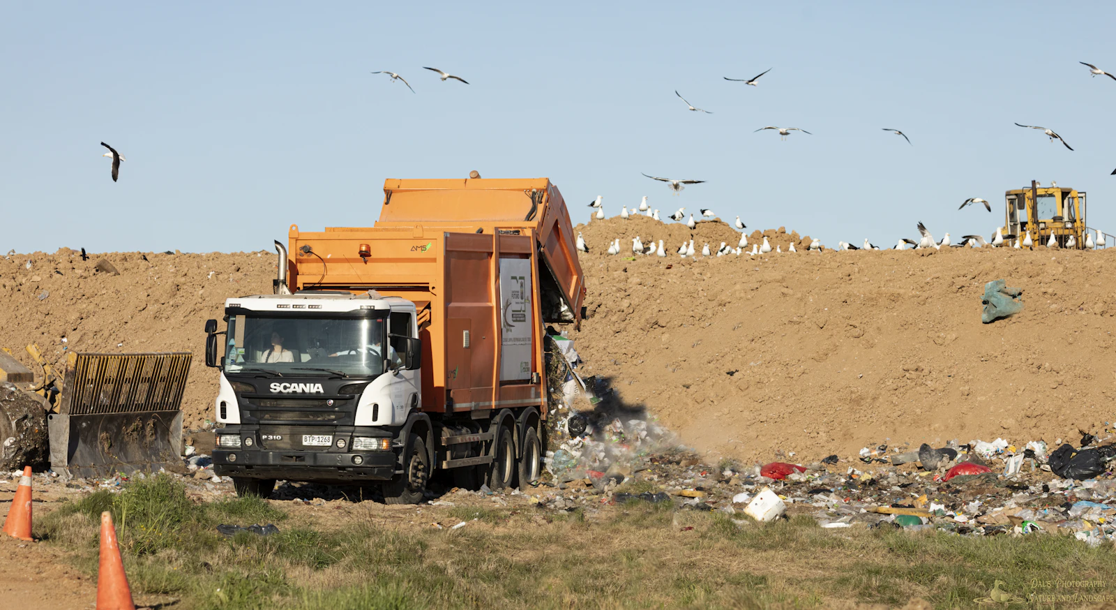A yellow and black heavy truck working on open ground