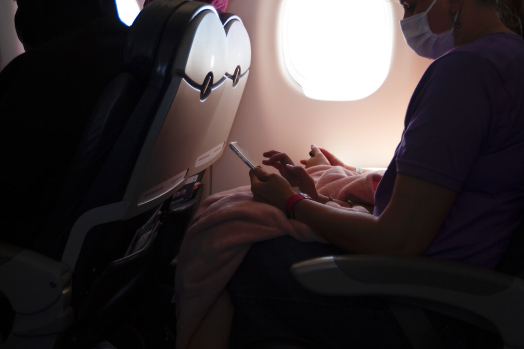 person in blue t-shirt sitting on black chair, In Flight Entertainment