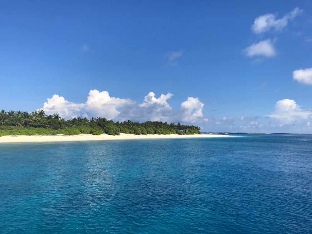 blue sea under blue sky and white clouds during daytime