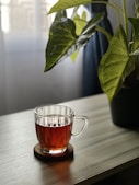 clear glass mug with brown liquid inside
