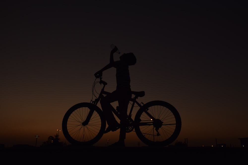 夕暮れ時に自転車に乗る男性のシルエット