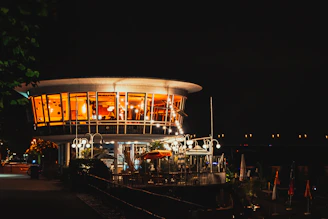 The Beacon Club’s exterior at night, illuminated by warm golden lighting that highlights its prestigious architecture.