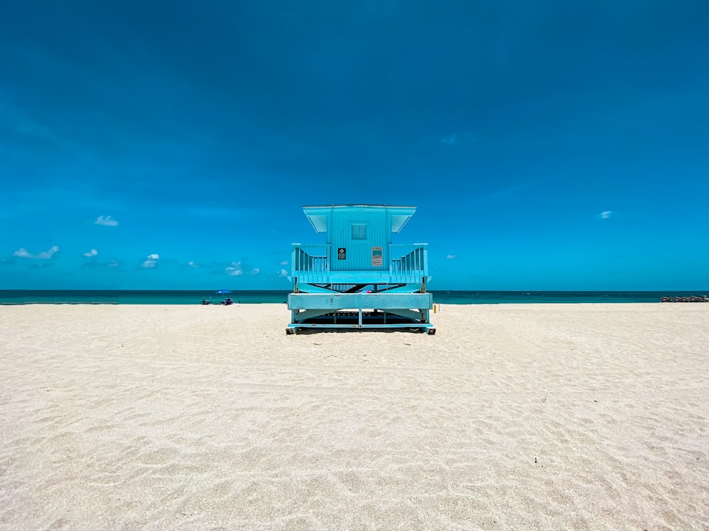 casa de salva-vidas azul e branca na praia durante o dia