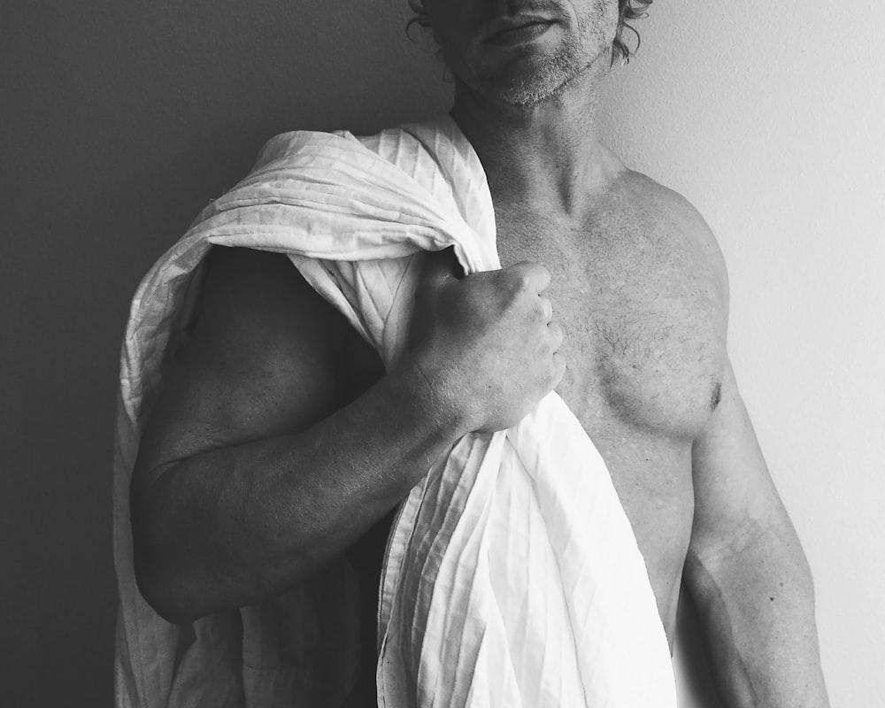man in white towel in grayscale photography