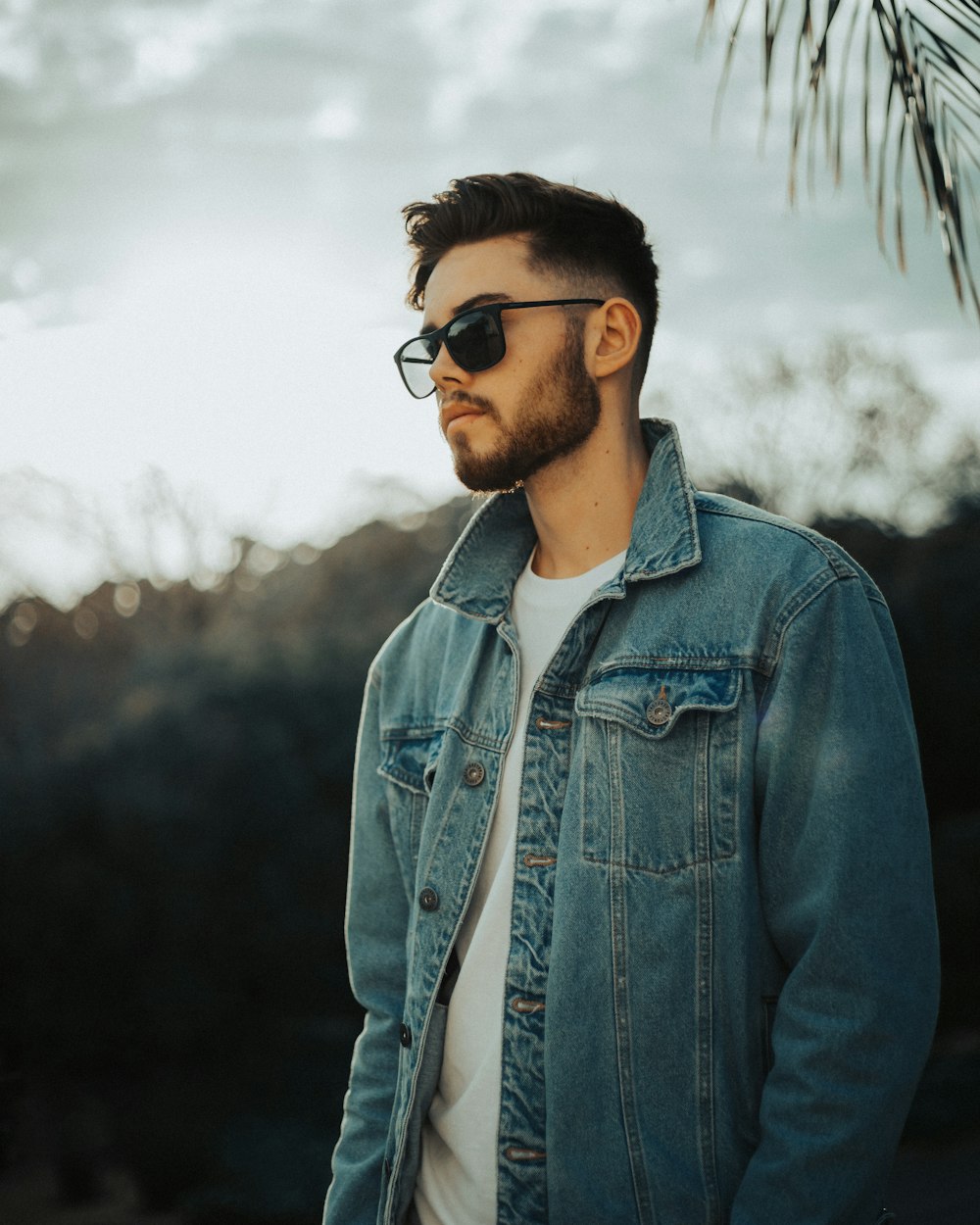 man in blue denim jacket wearing black sunglasses