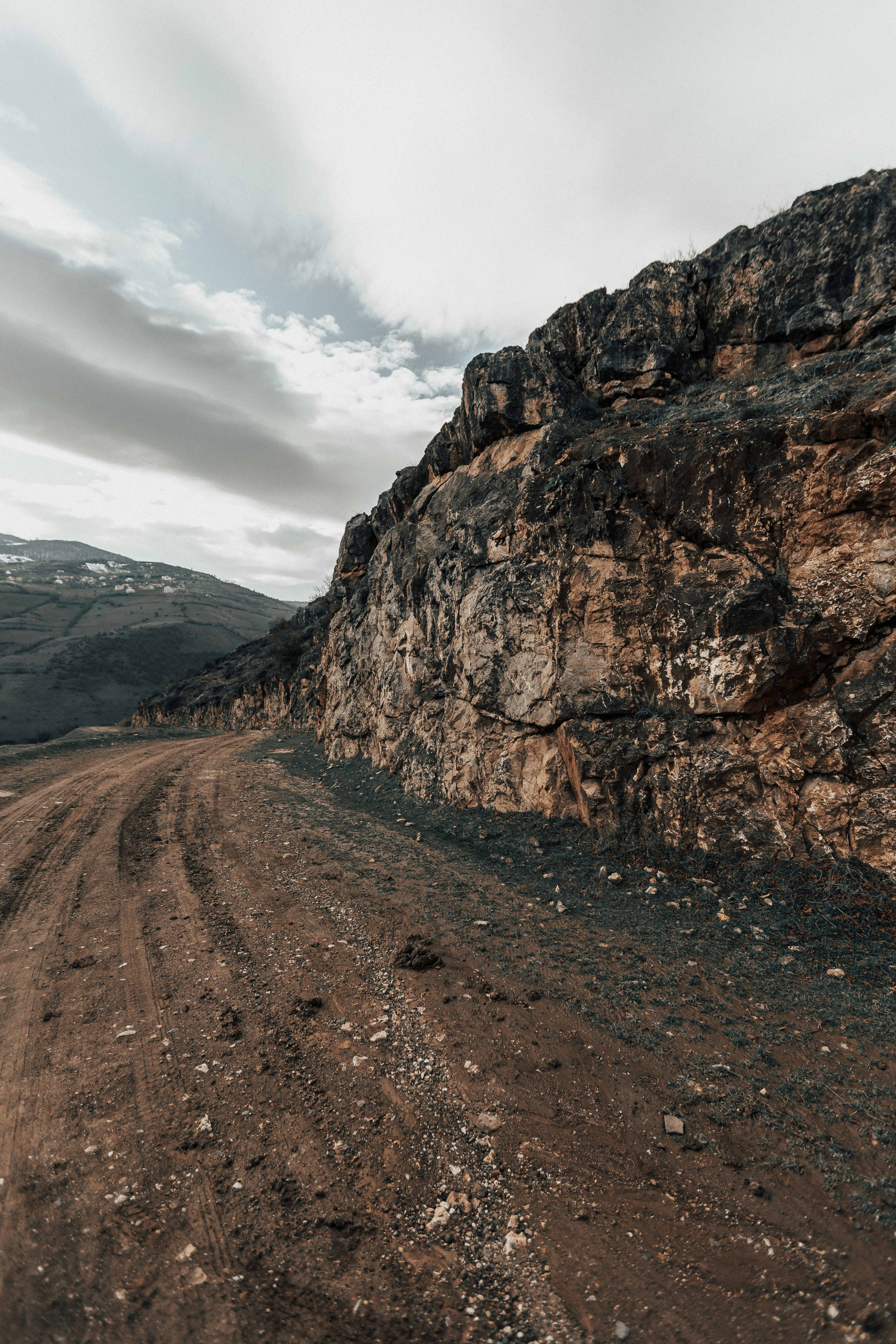 montagne rocheuse brune sous ciel nuageux blanc pendant la journée