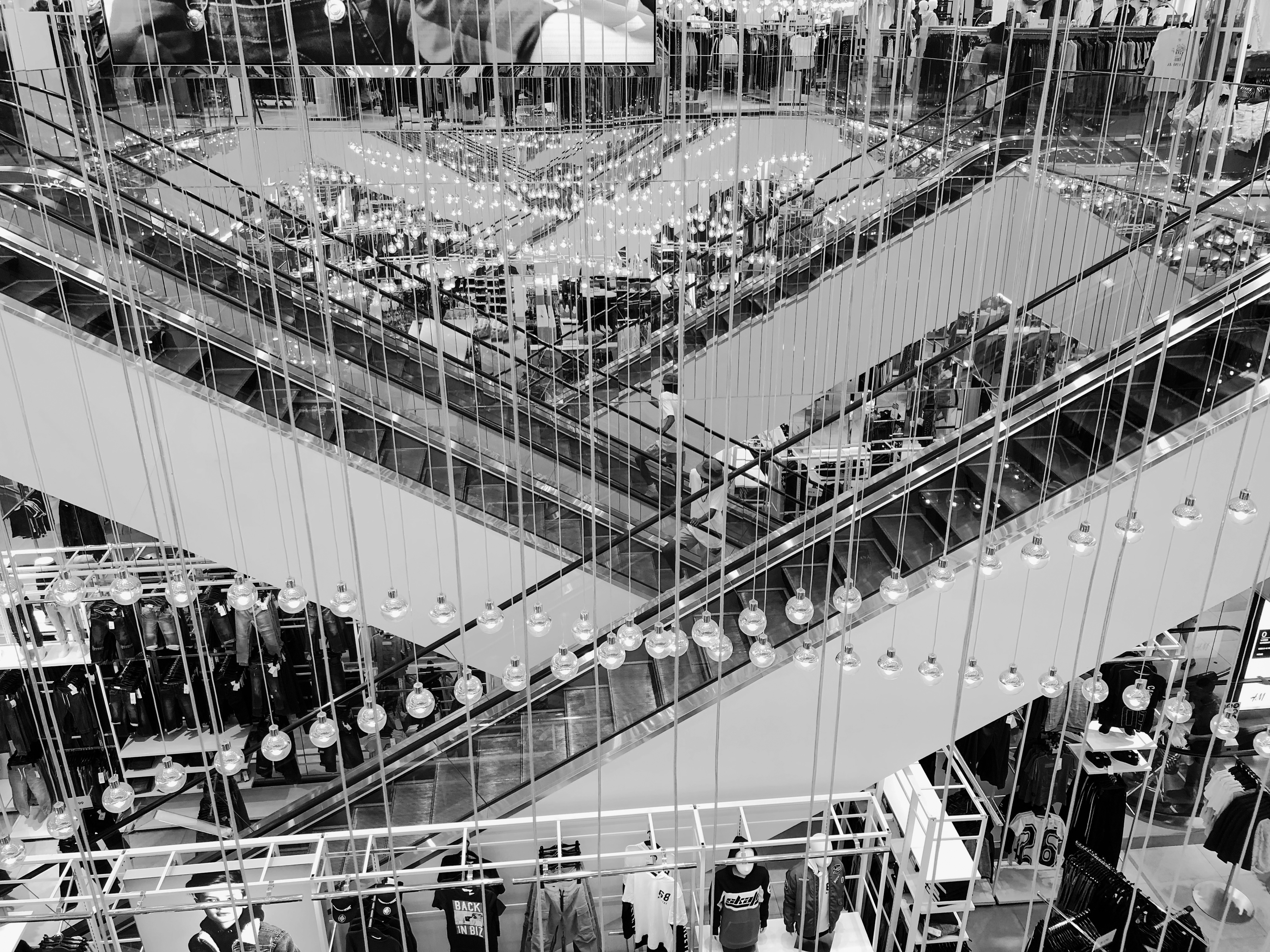 grayscale photo of people walking on the bridge