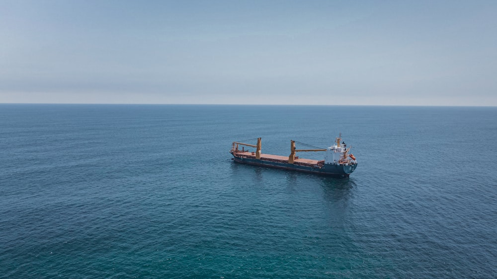 brown and white boat on sea during daytime