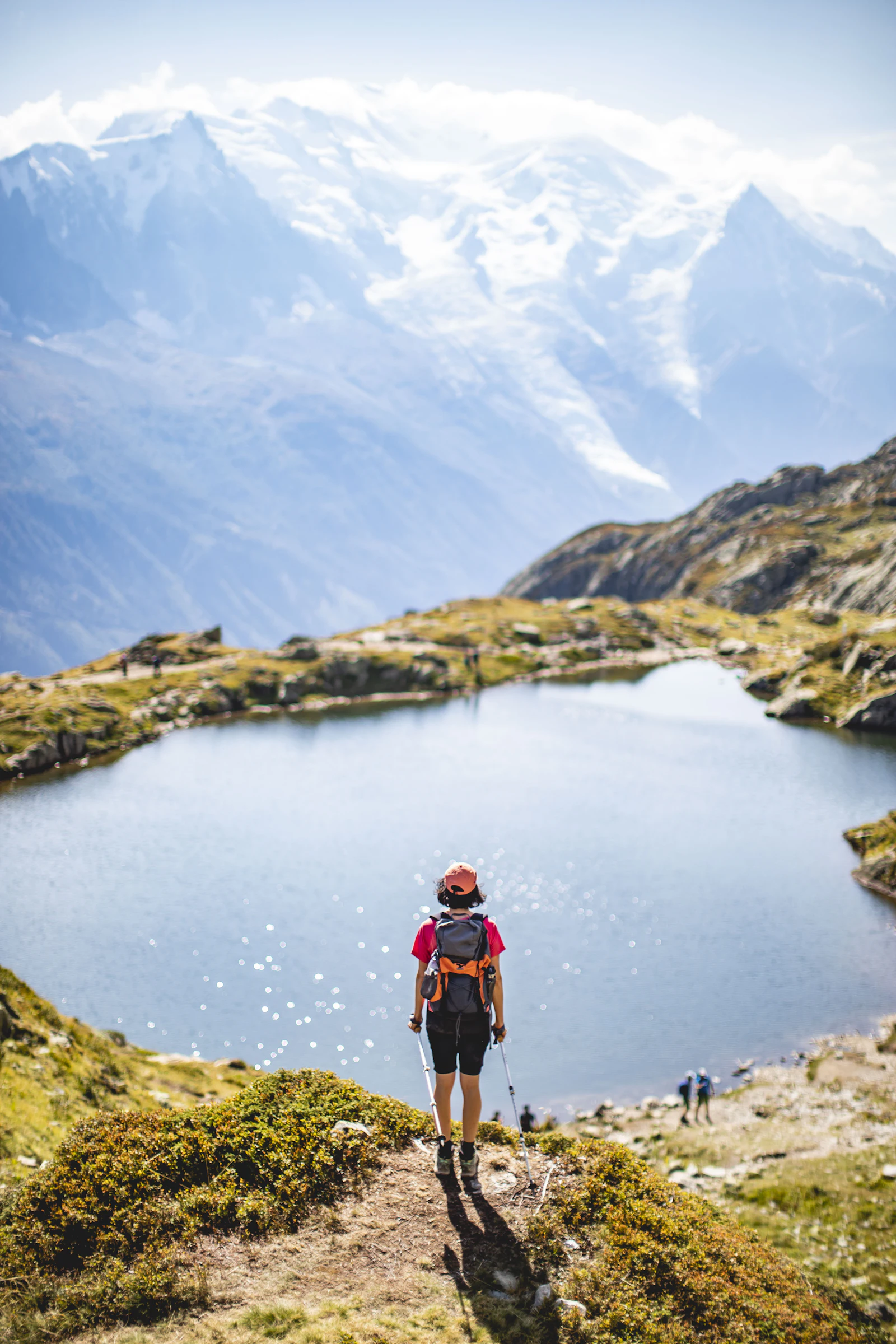 Randonneur face au massif du Mont-Blanc, près d'un lac d'altitude