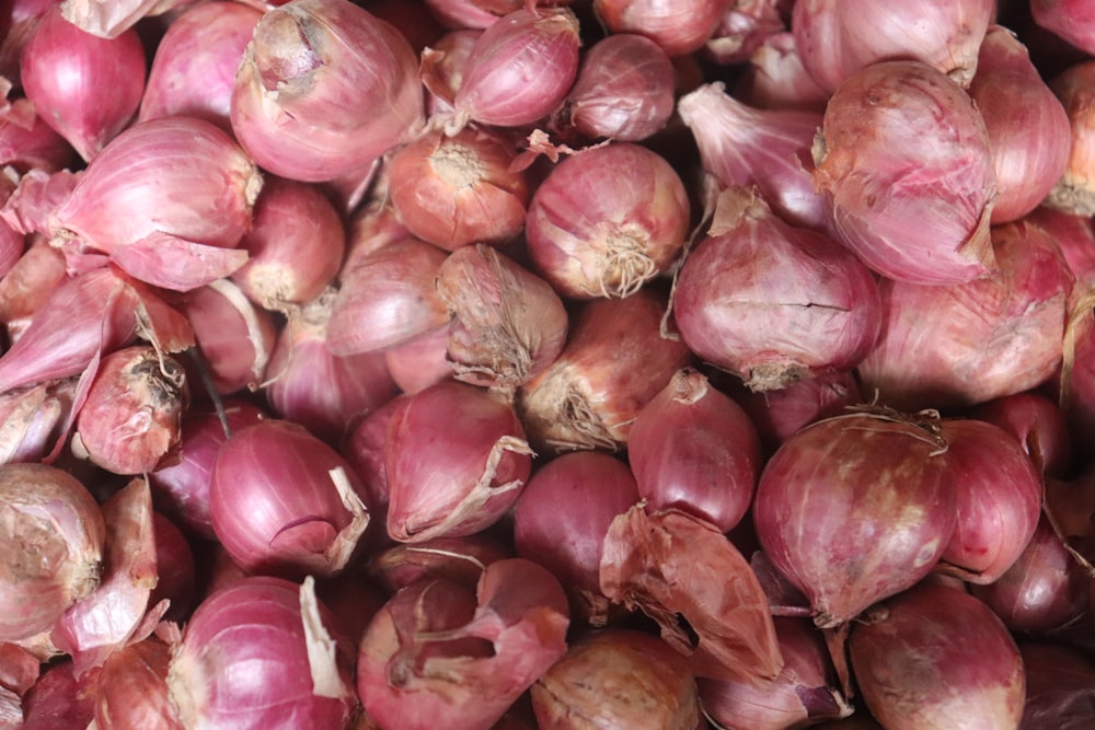red onion bulbs on brown wooden table