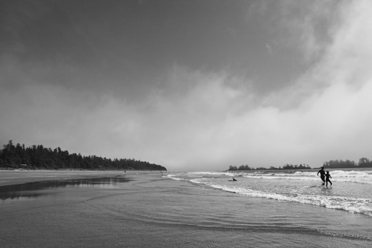 grayscale photo of sea waves crashing on shore in Tofino Canada