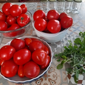 A cozy kitchen counter with fresh vegetables and canning jars ready for preserving.