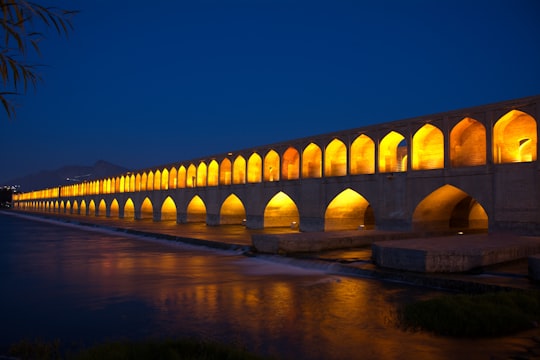 brown concrete bridge over river during night time in SioSe Pol Bridge Iran